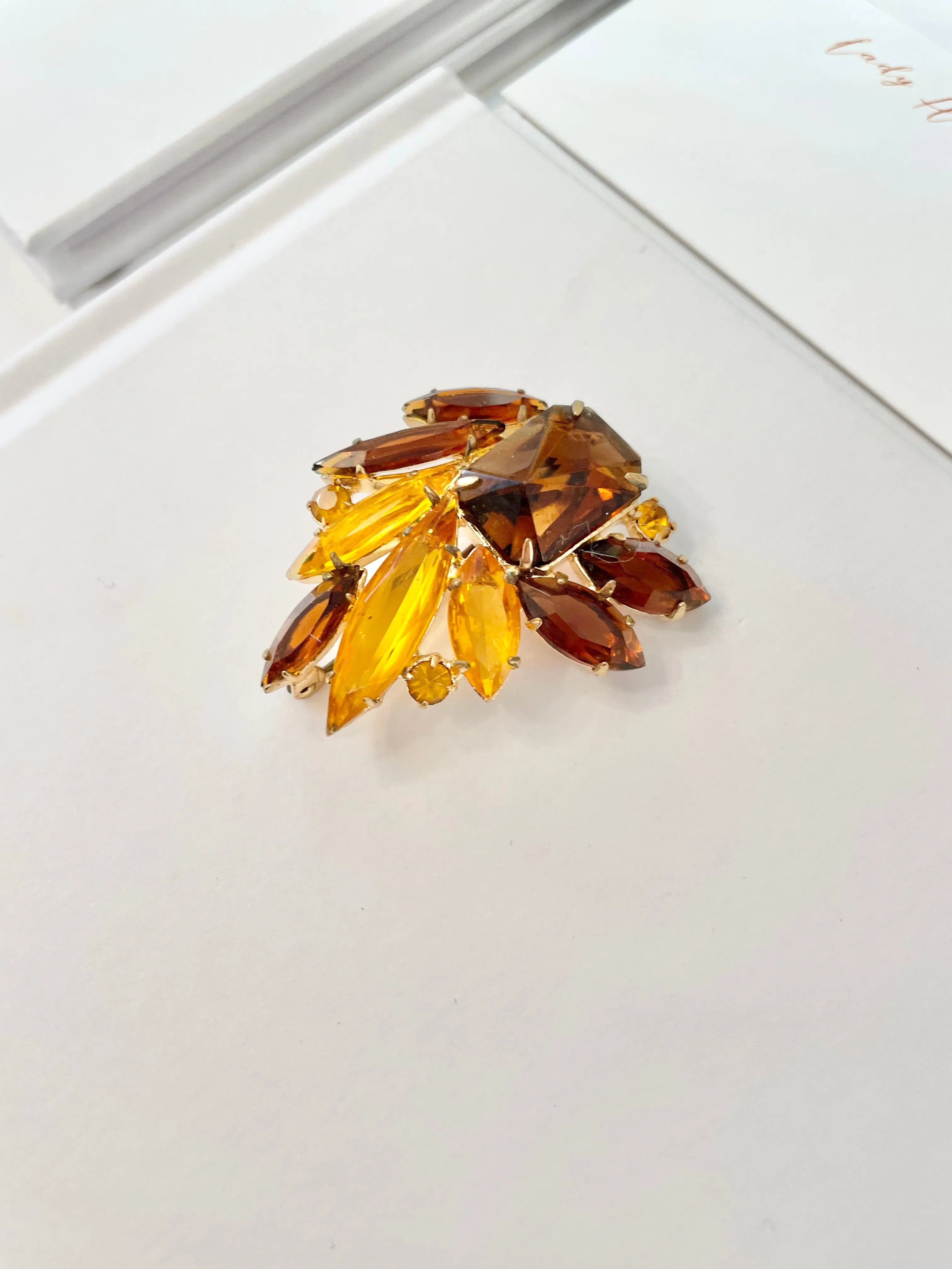The Socialite and her love of the classic brooch. This 1960's faux glass smoky topaz brooch is truly divine!